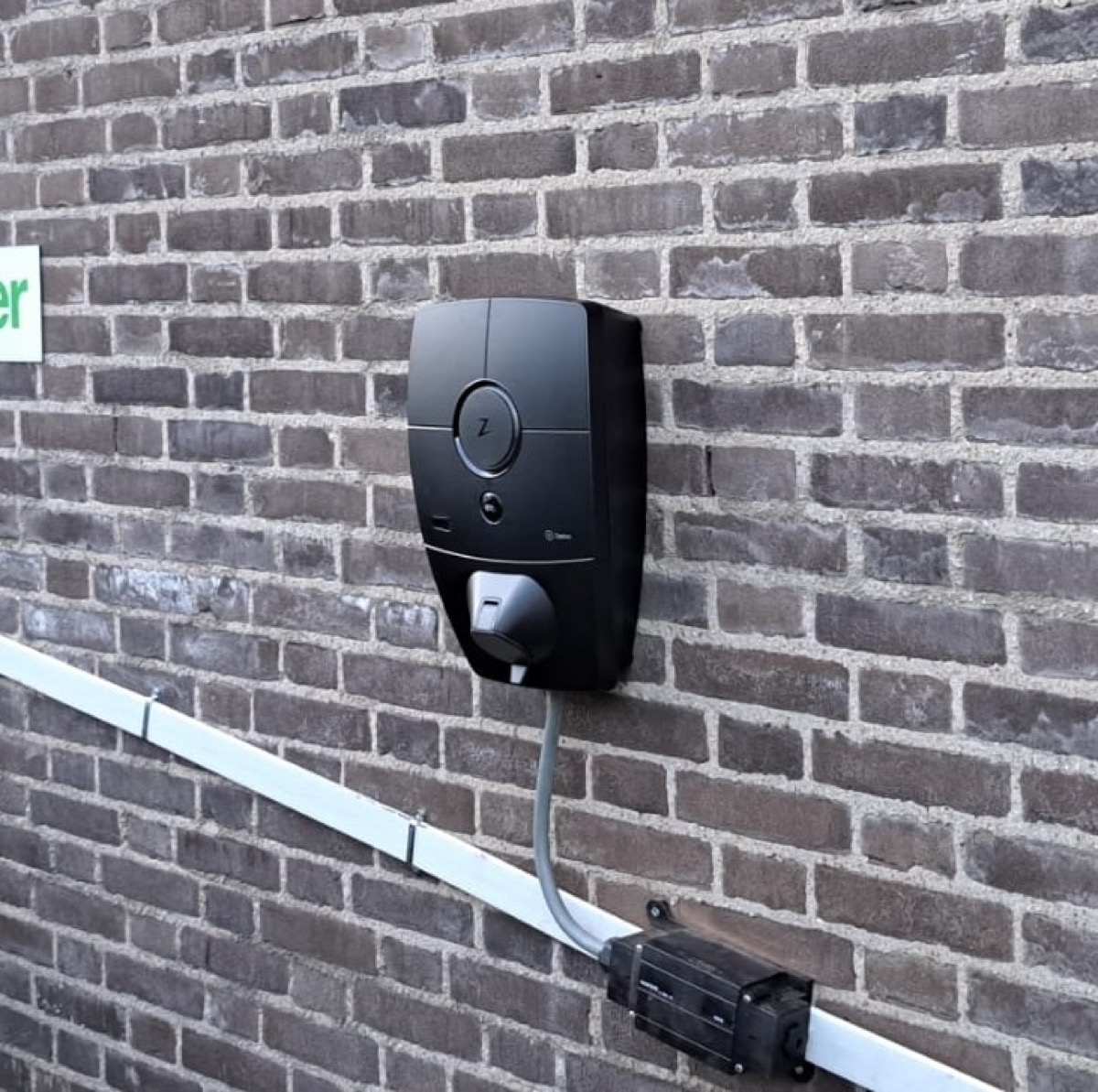 Strak afgewerkte Zaptec laadpaal installatie aan een gevel